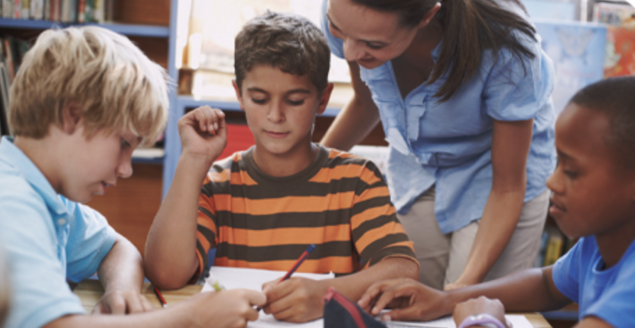 Private companies are also investing in tutoring projects A teacher tutoring a group of kids.